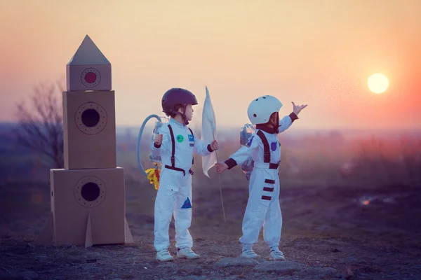 Duas crianças adoráveis, brincando no parque ao pôr-do-sol, vestidas como um — Fotografia de Stock