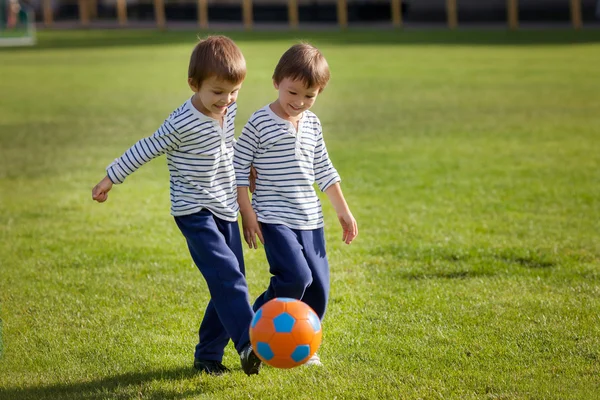 Dois meninos bonitos, jogando futebol — Fotografia de Stock