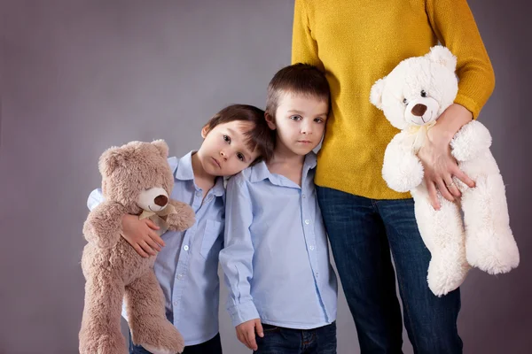 Sad little children, boys, hugging their mother at home, isolate — Stock Photo, Image