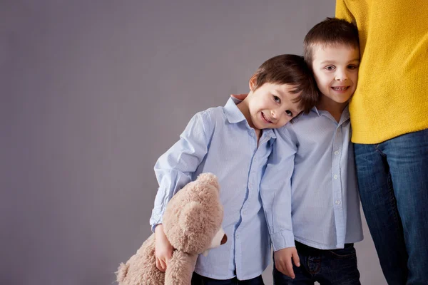 Happy little children, boys, hugging their mother at home, isola — Stock Photo, Image