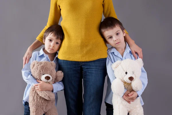 Sad little children, boys, hugging their mother at home, isolate — Stock Photo, Image