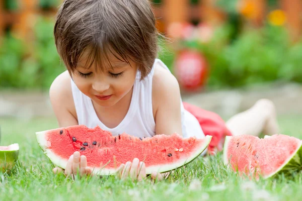 Ragazzo, mangiare anguria in giardino, estate — Foto Stock