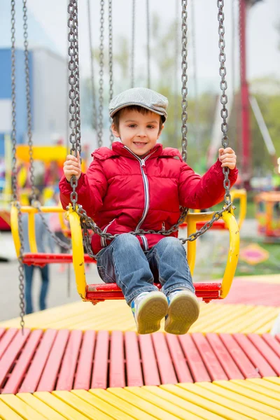 Lindos niños en un carrusel de cadena swing —  Fotos de Stock