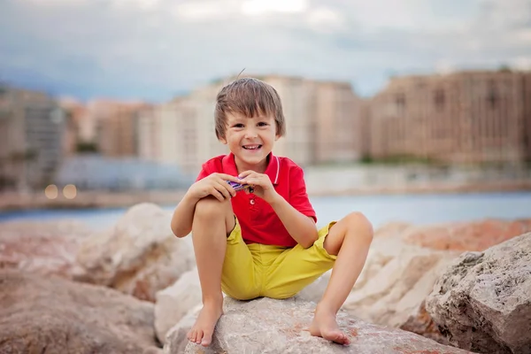 Jongen, spelen op het strand in de avond na regen met speelgoed — Stockfoto