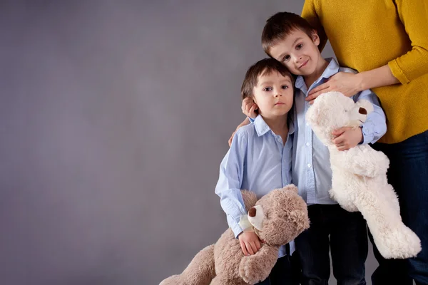 Hijitos tristes, chicos, abrazando a su madre en casa, aislar — Foto de Stock