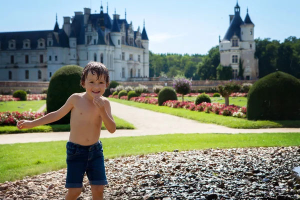 Menino bonito, brincando na chuva em frente a um castelo em Fra — Fotografia de Stock