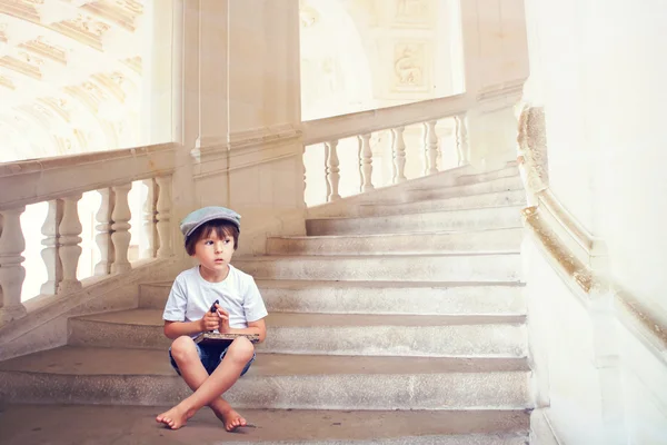 Adorable niño descalzo, sentado en una hermosa escalera w — Foto de Stock