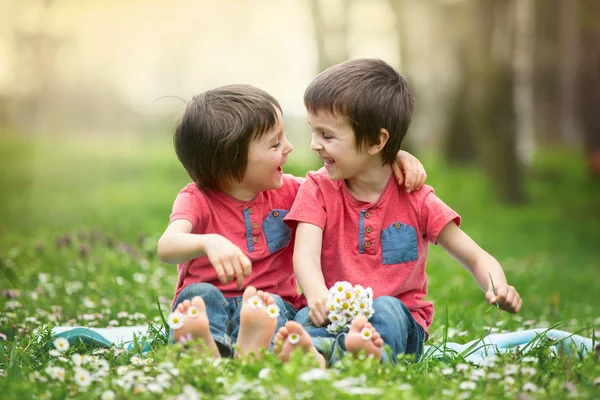 Niños felices, tumbados en la hierba, descalzos, margaritas —  Fotos de Stock