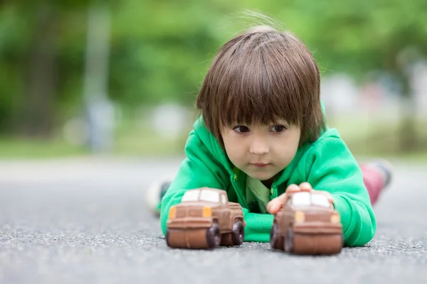 Legrační malý chlapec hrát s autem čokolády, venkovní — Stock fotografie