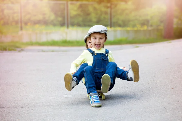 Urocze dzieci w wieku przedszkolnym, jazdy na deskorolce na ulicy — Zdjęcie stockowe