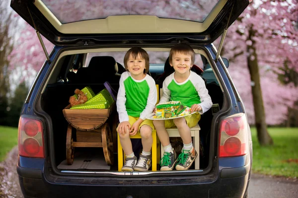 Sevimli çocuk, erkek kardeşler, l tutarak araba bagajında oturan — Stok fotoğraf