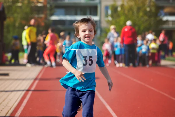 Niños en edad preescolar, corriendo en la pista en un maratón competi —  Fotos de Stock