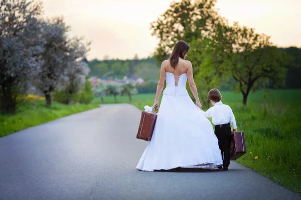 Jovem noiva na estrada com uma mala — Fotografia de Stock