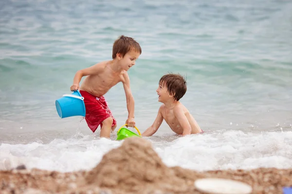 Dwoje dzieci, bracia chłopiec, gry na plaży z piasku zabawki — Zdjęcie stockowe