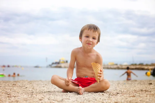 Doux petit enfant, garçon, manger de la glace sur la plage — Photo