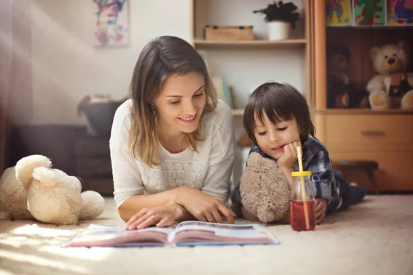 Giovane madre, leggere un libro per i suoi figli tho, ragazzi, nel livi — Foto Stock