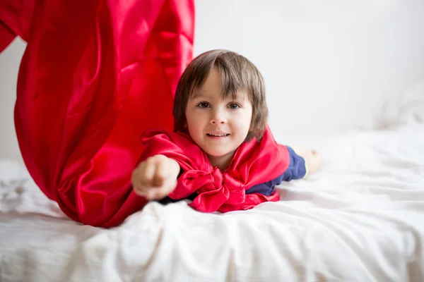 Süßer kleiner Vorschuljunge, der zu Hause Superhelden spielt — Stockfoto