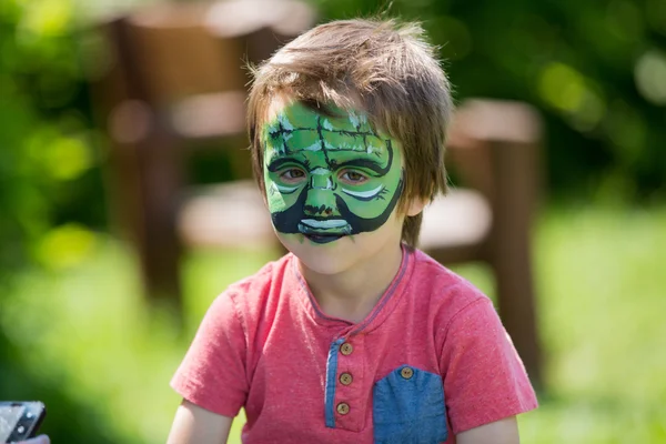 Lindo niño de cinco años. con la cara pintada en su — Foto de Stock