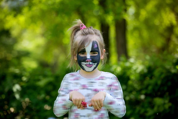 Linda niña de cinco años, que tiene su cara pintada como kitt — Foto de Stock