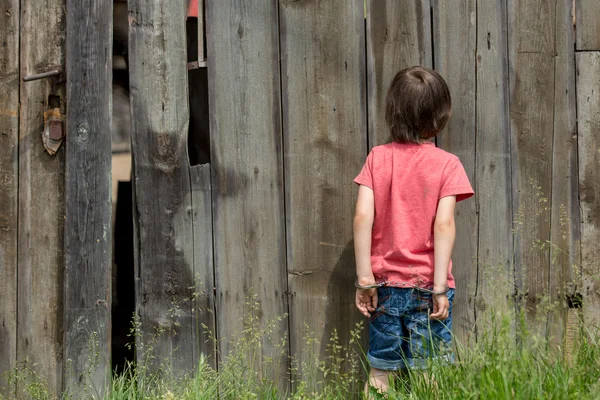 Schattige kleine jongen met de hand manchetten op zijn handen — Stockfoto