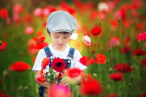 귀여운 유치원 아이 양 귀 비 필드에 야생 f의 꽃다발을 들고 — 스톡 사진