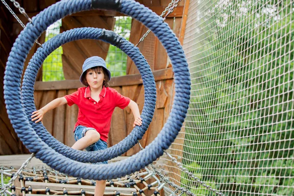 Schattig kind, jongen, klimmen in een touw Speeltuin structuur — Stockfoto