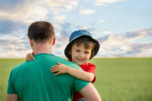 Father holding his son in a friend field — Stock Photo, Image