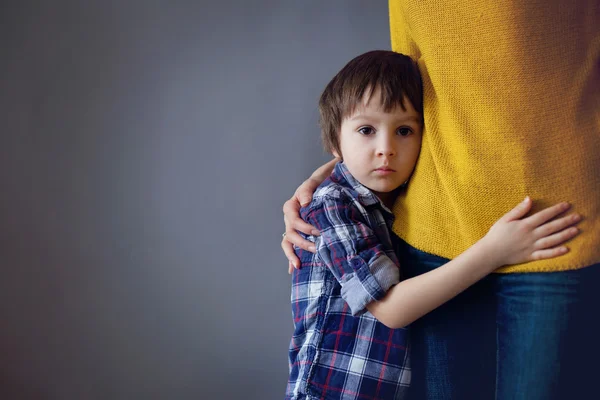 Beetje verdrietig kind, jongen, knuffelen zijn moeder thuis — Stockfoto