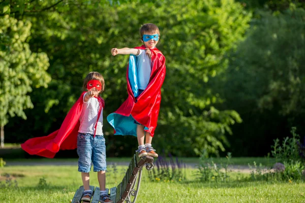 Két édes kis óvodáskorú gyermekek, fiúk, játék szuperhős — Stock Fotó