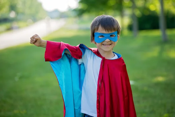 Édes óvodai kisfiú játszik a szuperhős a parkban — Stock Fotó