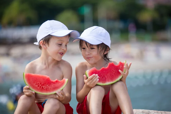 İki küçük çocuk üzerinde beac karpuz yeme, erkek kardeşler, — Stok fotoğraf