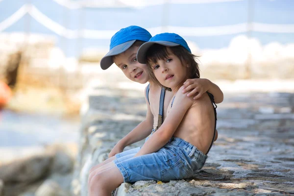 Twee kinderen, jongen broers, zittend op een Pier op de Middellandse Zee s — Stockfoto