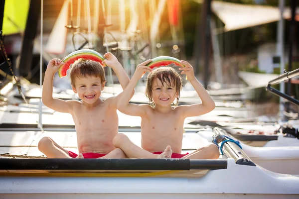 Dos niños pequeños, hermanos varones, comiendo sandía en la playa — Foto de Stock