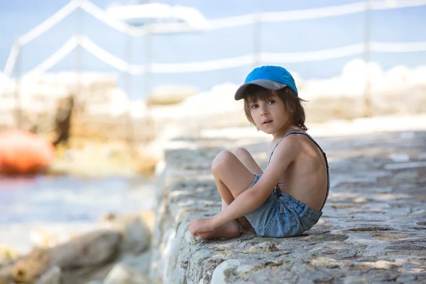 Carino ragazzo, seduto su un molo nel Mar Mediterraneo sulle rivie francesi — Foto Stock