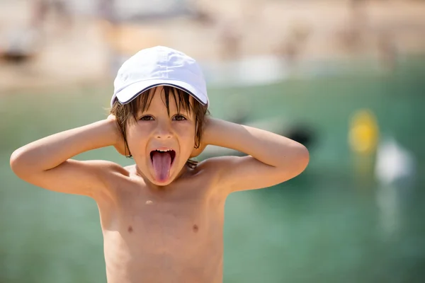 Lindo niño en la playa, jugando y haciendo caras divertidas — Foto de Stock