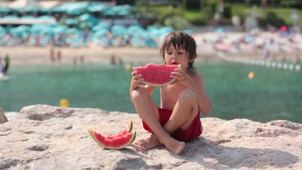 Ragazzino carino, ragazzo, mangiare anguria sulla spiaggia, estate — Video Stock