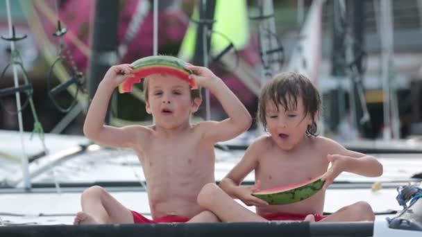 Dvě malé děti, chlapci bratři, jíst meloun na pláž, léto — Stock video
