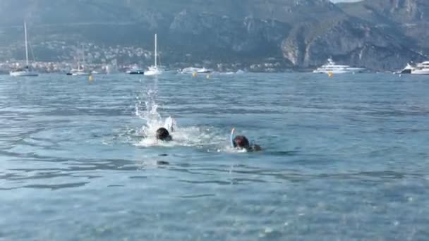 Nasıl yüzüleceğini öğrenme Yüzme gözlükler ve Fransız Rivierası, denizde Yüzme şnorkel ile iki yakışıklı çocuk — Stok video