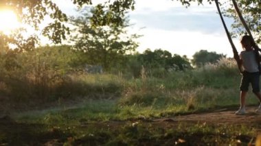 İki çocuk, erkek kardeşler, sunset bulvarında bir salıncak arka bahçesinde üzerinde eğleniyor 