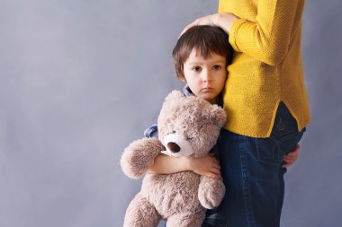 Annesi evde sarılma üzgün küçük bir çocuk, çocuk,