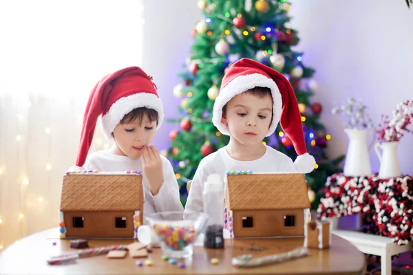 Två söta pojkar, bröder, att göra pepparkakshus cookies — Stockfoto