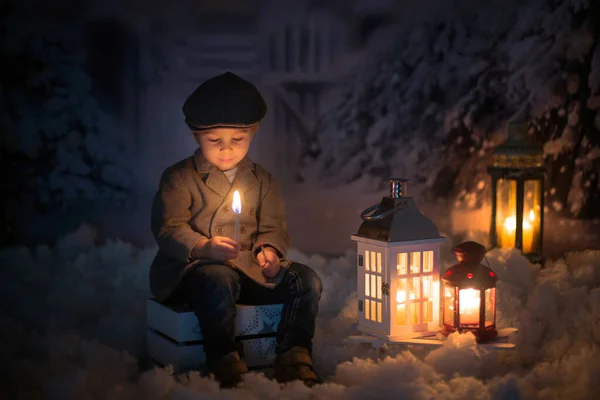 雪の中屋外に座って炎を見ている男の子 — ストック写真