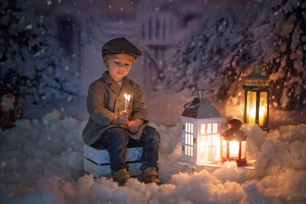 Ragazzino Guardando Fiamma Dal Fiammifero Seduto Nella Neve All Aperto — Foto Stock