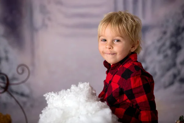 冬の服を着たかわいい幼児の男の子 雪の中で遊んで クリスマススタジオショット — ストック写真