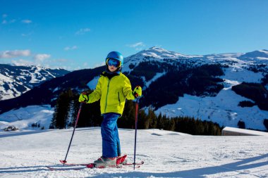 Çocuğum, güneşli bir günde kış kayak merkezinde kayak yapmak, manzaranın tadını çıkarmak