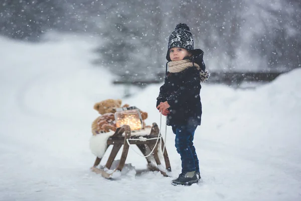 雪の中でテディベアと遊んでかわいい男の子 冬時間 雪の日におもちゃで遊んでいる小さな幼児 — ストック写真