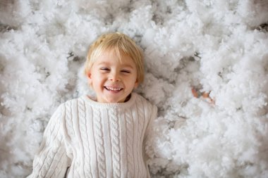 Küçük bir çocuk, küçük bir çocuk, Noel Baba 'ya posta kutusuyla mektup yolluyor, etrafında Noel süsü, açık havada karla vuruyor.