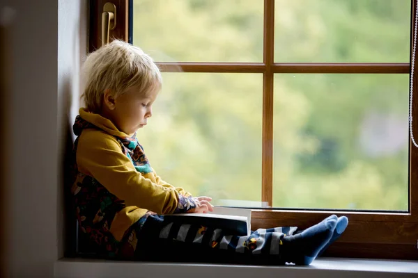 Lindo Niño Pequeño Niño Rubio Sentado Ventana Casa Libro Lectura —  Fotos de Stock