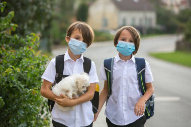 Okul çocukları, çocuklar, yaz tatilinden sonra okula geri dönmek, çocuklar Coronavirus COVID 19 yüzünden maske takarak okula gitmek.