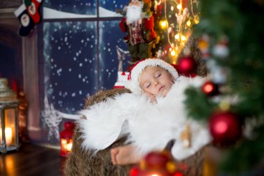 Güzel çocuk, küçük çocuk, Noel arifesinde evde rahat bir atmosferde uyuyor.